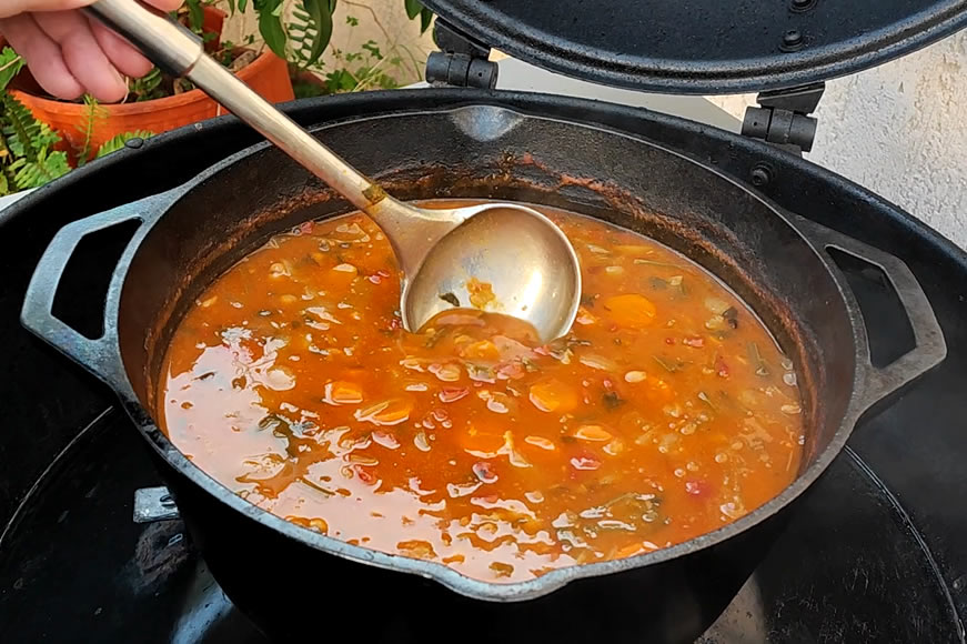 Φασολάδα σε μαντεμένια κατσαρόλα Lodge επάνω σε ψησταριά BBQ Outdoorchef
