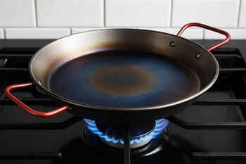 Η διαδικασία seasoning σε παραδοσιακή carbon steel paellera, όπως προτείνεται στον οδηγό του Cookpro.gr